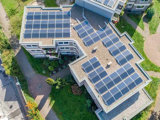 Mehrfamilienhaus mit Solaranlage auf dem Dach, symbolisch für Mieterstrom-Projekte-min